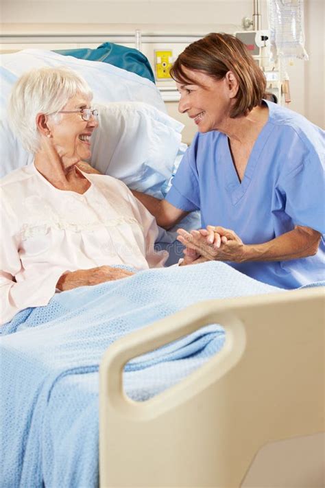 Nurse Talking To Senior Female Patient In Hospital Bed Stock Image