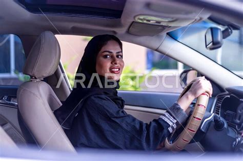 امرأة عربية خليجية سعودية محجبة ، تقود السيارة بمتعة وسعادة ، حرية القيادة للمرأة العربية