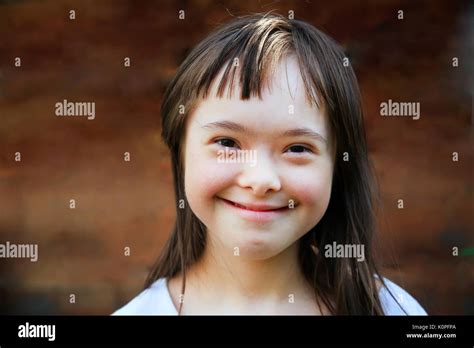Cute Smiling Down Syndrome Girl On The Brown Background Stock Photo Alamy