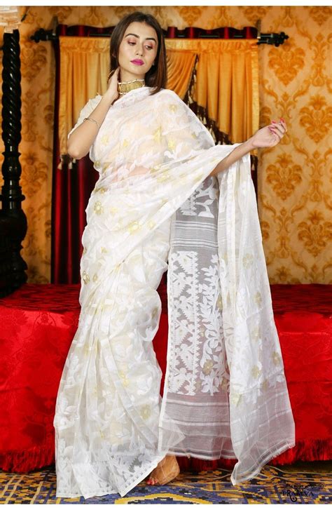 A Woman In A White Sari Posing For The Camera