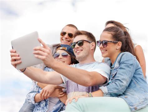 Group Of Smiling Teenagers Looking At Tablet Pc Stock Image Image Of
