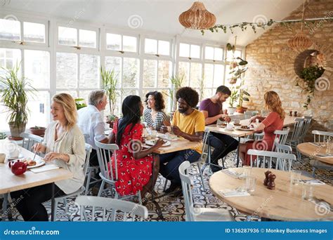 Customers Eating At A Busy Restaurant In The Day Time Stock Photo