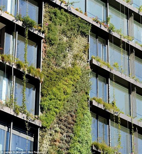 An Apartment Building With Plants Growing On The Side