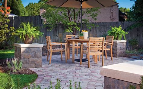 An Outdoor Dining Area With Table And Chairs Under An Umbrella In The
