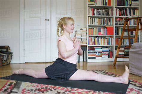 Flexible Woman Doing Splits While Exercising In Living Room At Home Stock Photo Dissolve