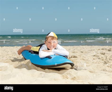 Portrait Of Boy Nipper Child Surf Life Savers Lying On Surfboard At