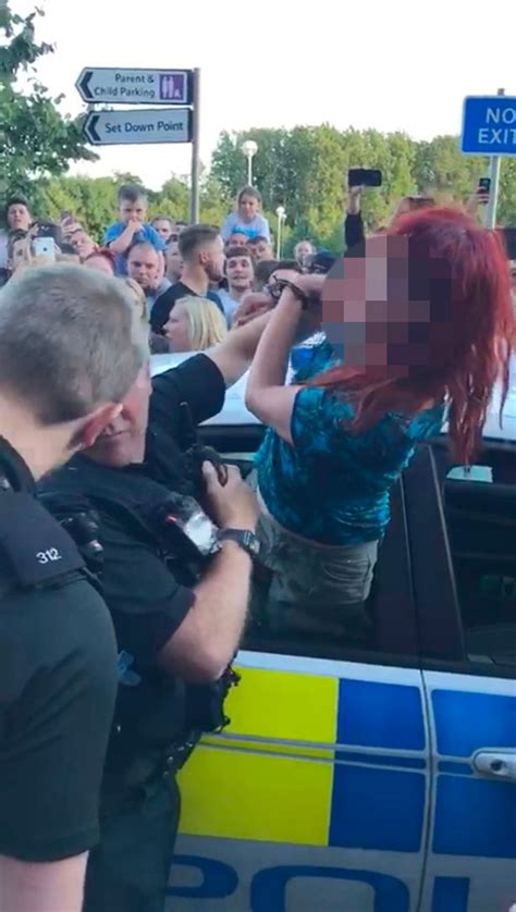 Handcuffed Woman Tries To Climb Out Of Police Car Window And Spits At