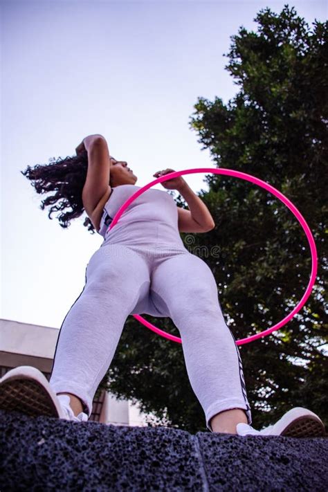 From Below A Slim Woman Plays Hula Hoop On The Street Stock Image