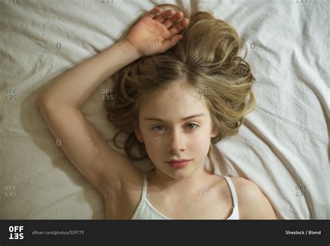 Serious Caucasian Girl Laying On Bed Stock Photo OFFSET