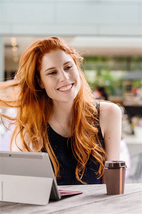 Beautiful Redhead Using Computer In Cafe By Gillian Vann