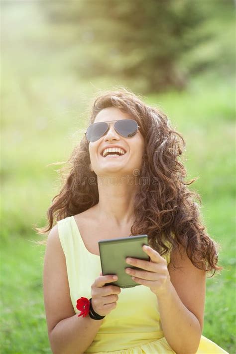 Beautiful Woman Laughing In The Park Reading E Book Stock Photo Image Of Attractive Green