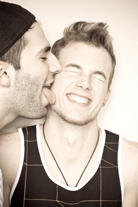 Two Men Are Kissing Each Other While One Man Is Wearing A Hat And The Other Has His Eyes Closed
