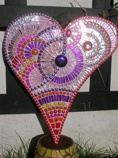 A Heart Shaped Mosaic Piece Sitting On Top Of A Potted Plant