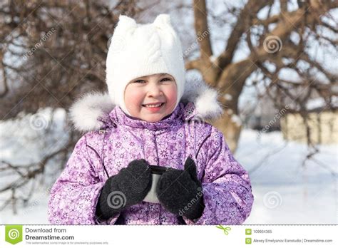 Little Beautiful Girl Drinks Tea In The Street In Winter
