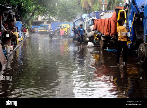 commuters make their way along a waterlogged street following monsoon rainfalls in dhaka