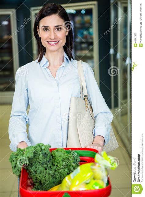mulher de sorriso que empurra o trole no corredor imagem de stock imagem de lifestyle alegria
