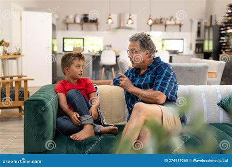 Caucasian Senior Man Gesturing And Talking With Cute Grandson While