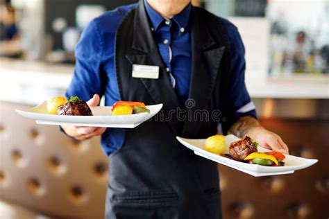 Waiter Carrying Two Plates With Meat Dish On Some Festive Event Stock