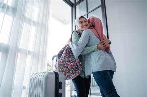 Une Femme Hijab Embrasse Sa Sœur Lorsquelle Se Rencontre à La Porte De La Maison Photo Premium
