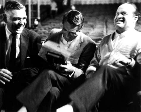 Four Men Sitting On A Bench Laughing And Looking At Something