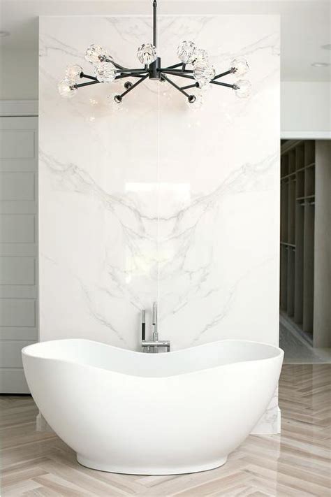 A freestanding bathtub makes this bathroom chic and modern. Modern Freestanding Bathtub in Front of Marble Wall ...