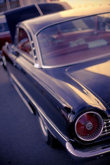 An Old Black Car Parked In A Parking Lot