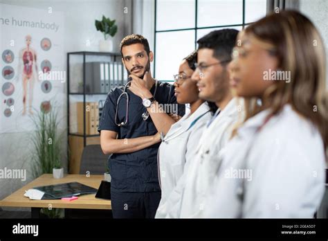 Blurred Profile View Of Diverse Multi Ethnic Team Of Doctors Standing