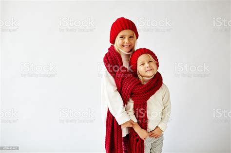Lovely Little Sisters Wearing Warm Knit Hats And Scarf Stock Photo