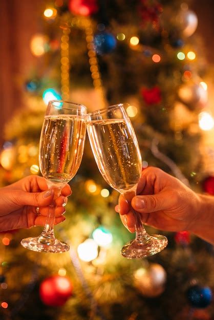 Premium Photo Two Hands Clink Glasses With Champagne Christmas