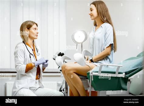 gynecologist preparing for an examination procedure for a pregnant woman sitting on a