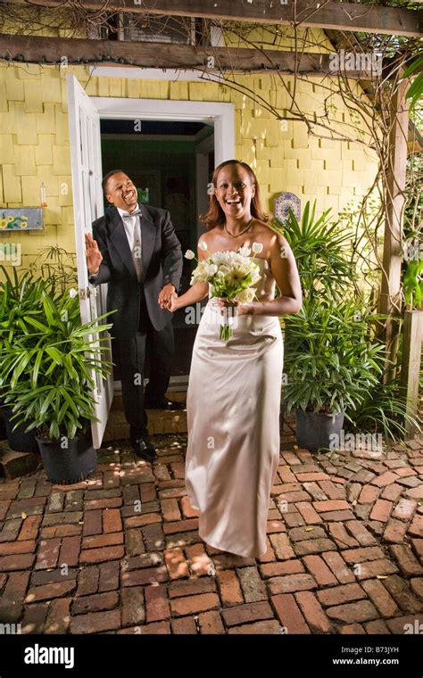 Happy African American Bride Leading Her Groom Through Door On Wedding
