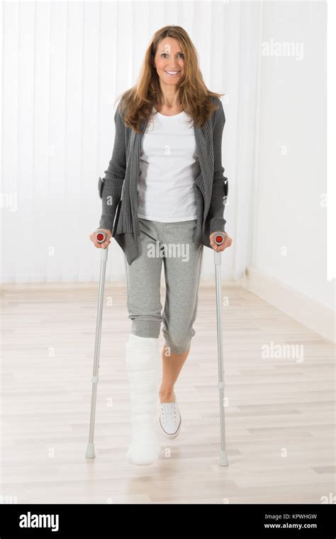 Woman Holding Crutches While Walking Stock Photo Alamy