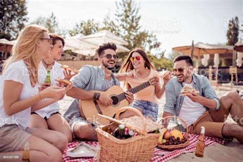 Group Of Happy Young People Having A Picnic On The Beach Stock Photo 