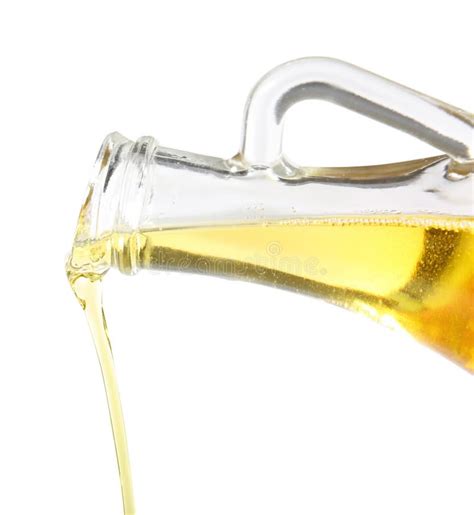 Pouring Of Olive Oil From Glass Bottle Into Spoon On White Background