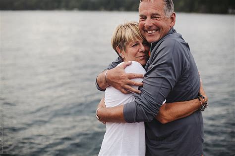 Fun Mature Couple Hugging Together On Dock At The Lake By Ameris