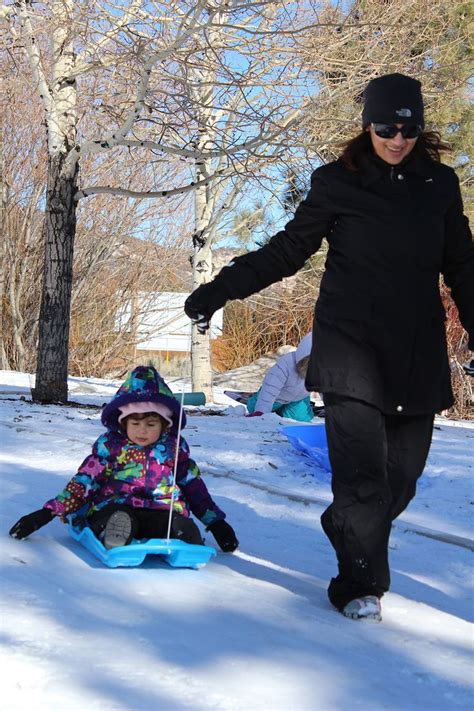 Mom And Baby Having Fun In The Snow With The Slippery Racer Downhill