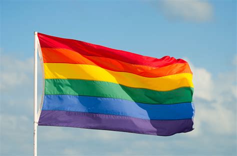 Gay Pride Rainbow Flag Flying In The Wind On Flag Pole Stock Photo