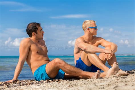 Två Stiliga Unga Män Som Pratar På En Strand Fotografering för