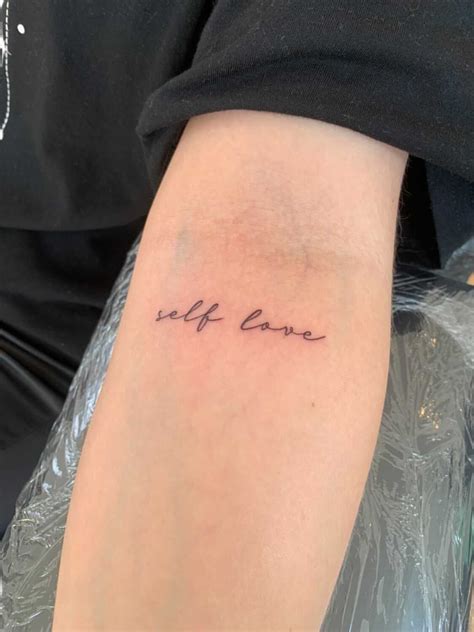 A Woman S Arm With The Word Self Love Tattooed On Her Left Arm In