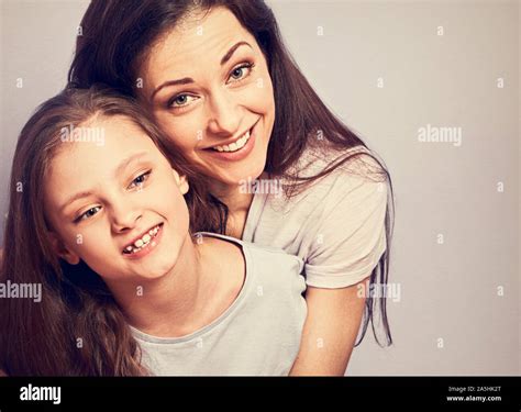 Happy Smiling Emotion Mother Cuddling Her Cute Daughter Sitting On The Floor With Love On Purple