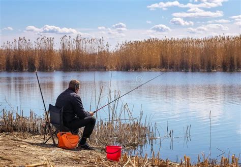 Fisherman Sitting On A Chair With A Fishing Rod Stock Photo Image Of