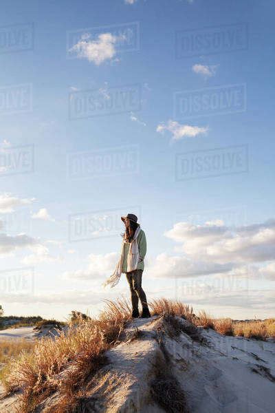 Woman Standing On Sand Dune Stock Photo Dissolve