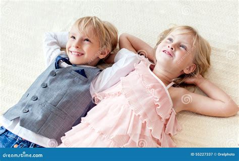 Брат и сестра лежат на поле Стоковое Изображение изображение насчитывающей позитивность
