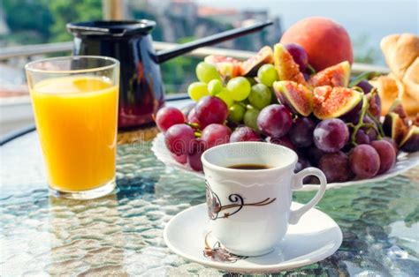 Breakfast Table With Coffee Orange Juice Fruits And Croissants Stock