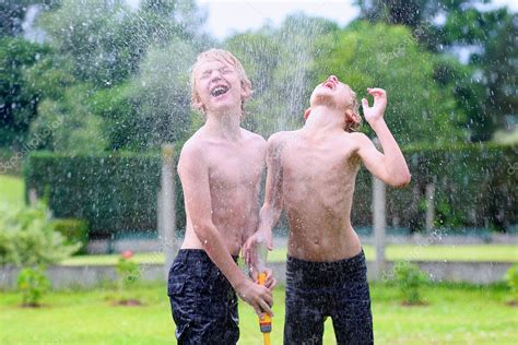 Two Happy Boys Playing In The Garden With Watering Hose — Stock Photo