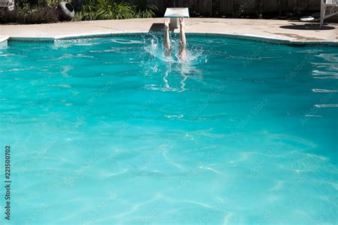 Woman Jumping Off A Diving Board Into A Swimming Pool Legs Above The Water Woman Diving Into