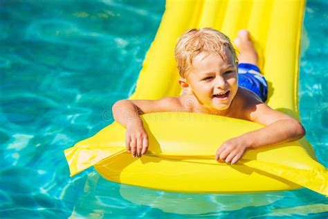 Boy Relaxing And Having Fun In Swimming Pool On Yellow Raft Stock Image