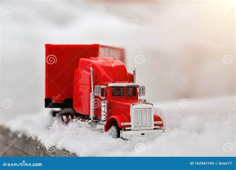 Red Toy Truck Rides on a Winter Snowy Road. Wood Flooring Stock Image