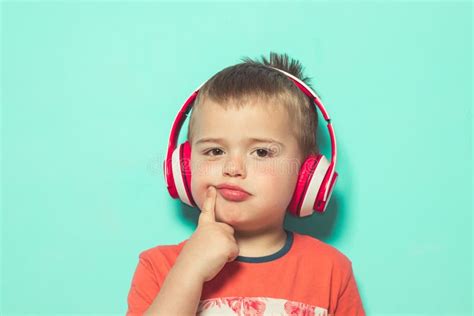 Niño Que Escucha La Música Con Los Auriculares Foto De Archivo Imagen