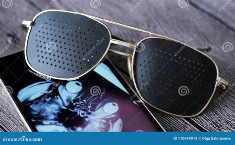 Black Medical Glasses With Holes And And The X Ray Image On The Smartphone Display Stock Image